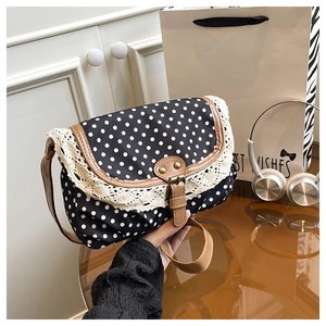 Détail du sac en toile à pois avec bordure en dentelle, passepoil et boucle en cuir
