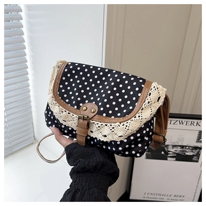 Détail du sac rétro à pois en toile avec bordure en dentelle et bandoulière en cuir marron