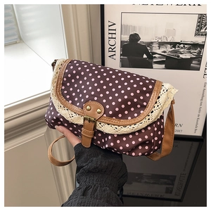 Détail du sac à pois vintage avec bordure en dentelle et sangle à boucle en cuir