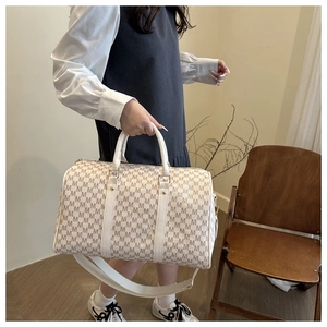 Detail of printed large capacity travel bag with monogram pattern and wide strap