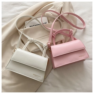 Detail of elegant PU leather crossbody bags featuring knotted handles and flap closures