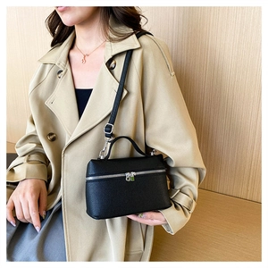Close-up of black lychee leather handbag with silver hardware and adjustable strap