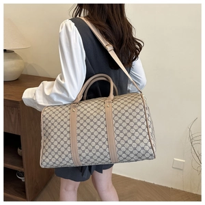 Detailed side view of a large printed travel bag with leather handles on a female model