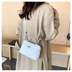 Close-up of white lychee pattern leather crossbody bag with silver zipper detail