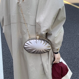 Elegant champagne gold shell evening bag with pleated texture and pearl clasp on chain
