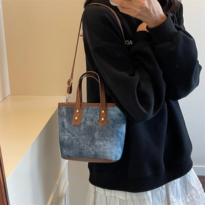 Sac seau en denim vintage avec bordure en cuir marron et rivets dorés femme