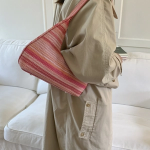 Women's woven shoulder bag with pink multi-color stripes and wide strap shown on model