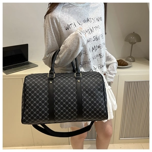 Detail of printed large travel tote bag featuring leather handles and monogram pattern