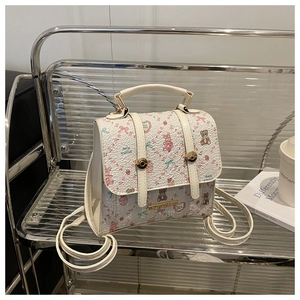 Detailed close-up of cute floral print mini backpack with golden buckle and textured leather