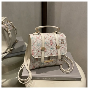 Detail view of mini backpack with cute cartoon floral prints and gold metallic buckle