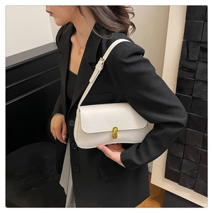 Detail of elegant gold metal lock buckle and smooth white leather on shoulder bag