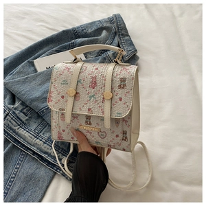 Detail of white mini backpack with pink teddy bear and floral print on denim jacket