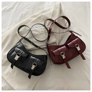 Detail of semi-matte PU leather hobo bag with dual front pockets and silver metal buckles