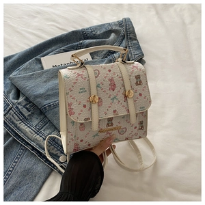 Detailed view of mini white backpack with cute rabbit prints and gold buckle straps