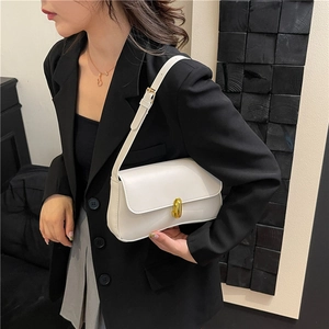 Minimalist white leather crossbody bag with elegant gold oval lock and adjustable strap