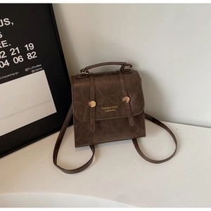 Detail view of small brown vintage backpack with gold buckle and smooth leather texture