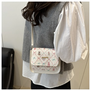 Detail of small white PU crossbody bag with cute animal prints and golden metal logo