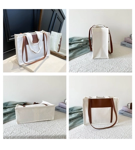 Detail view of large canvas tote bag with contrasting brown leather handles and pocket