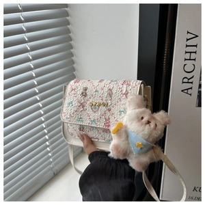 Detail of white jacquard crossbody bag with floral bear prints and plush bear charm