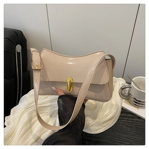 Detail of beige patent leather shoulder bag featuring a gold twist lock and adjustable strap