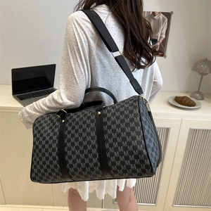 Large travel duffel bag with black M-letter pattern and adjustable shoulder strap