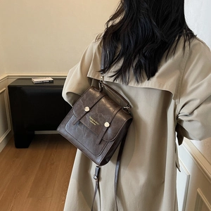 Retro dark brown leather backpack for women in preppy style with metal buckle detail