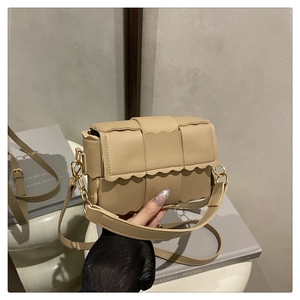 Détail du motif tressé et bordure ondulée sur le sac bandoulière beige