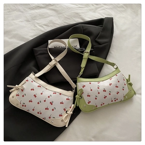 Detail view of cherry print shoulder bags with decorative side bows and metal rivets