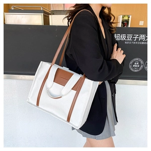 Detail of canvas tote bag with contrast leather handles and Fashion Bag embossed text