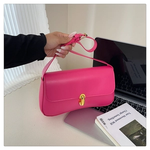 Fuchsia fasion handbag detail featuring a polished gold twist lock and smooth leather texture