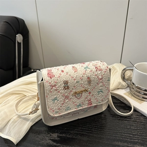 Cute cartoon floral crossbody bag with bear prints and textured fabric in a cafe setting