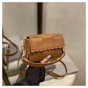Détail du sac à main en cuir marron caramel avec texture tissée large et bords festonnés