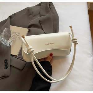 Macro shot of white leather shoulder bag detail with Fashion & Bags lettering and golden tips