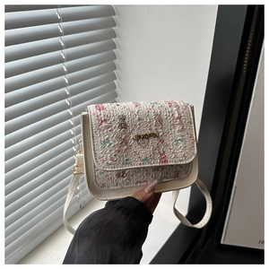Close-up of floral crossbody bag with teddy bear print and golden JINGPIN metal logo