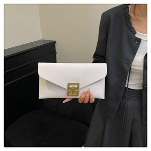 Detail of white leather envelope clutch featuring a square gold metal clasp and sleek flap