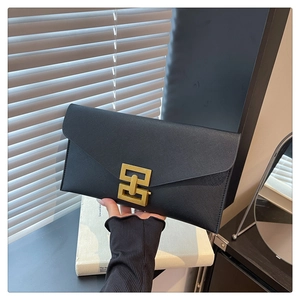 Close-up of black saffiano leather envelope clutch with golden square buckle detail