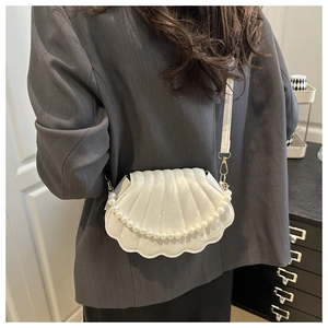 Detail of white shell-shaped shoulder bag with pearl chain and pleated texture