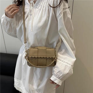 Sac bandoulière tressé beige avec bords ondulés et double sangle sur mannequin