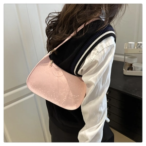 Détail du sac à bandoulière rose avec texture peau de serpent et fermeture éclair dorée