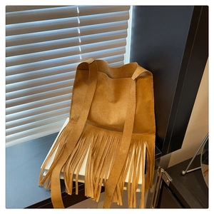Détail du sac bandoulière en daim camel avec de longues franges et une large bandoulière
