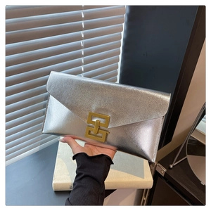 Detailed view of silver envelope clutch bag with premium metal finish and gold lock buckle