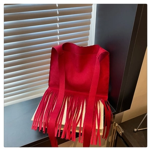 Détail du sac à bandoulière rouge avec franges bohèmes et texture en daim