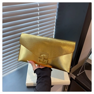 Macro view of golden envelope clutch bag showing cross-grain texture and metal lock