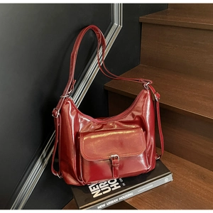 Detailed view of a retro wine red hobo bag with silver hardware on a wooden staircase
