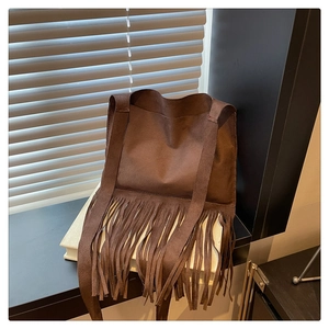 Gros plan détaillé du sac en daim marron avec de longues franges et coutures apparentes