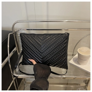 Détail de pochette en cuir PU noir avec clous argentés et motif matelassé en chevron