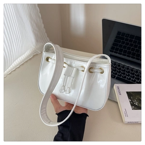 Close-up of white glossy PU leather bag with drawstring and gold metal eyelet details