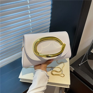 Minimalist white leather crossbody bag with a large gold oval buckle and chain strap