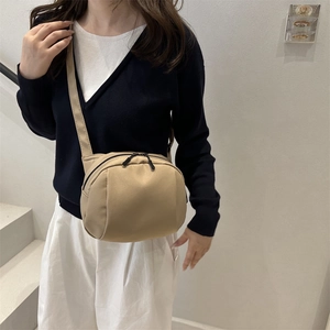 Minimalist beige nylon shell crossbody bag with adjustable strap and large capacity