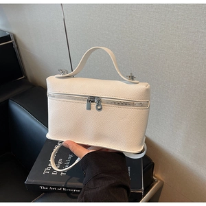 Detail of white pebbled leather mini box bag featuring silver double zippers and top handle